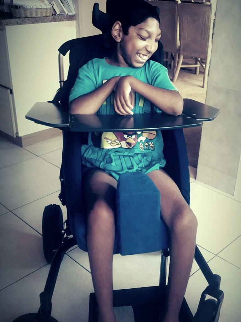 Jaden sitting in his supportive chair while listening to his music.