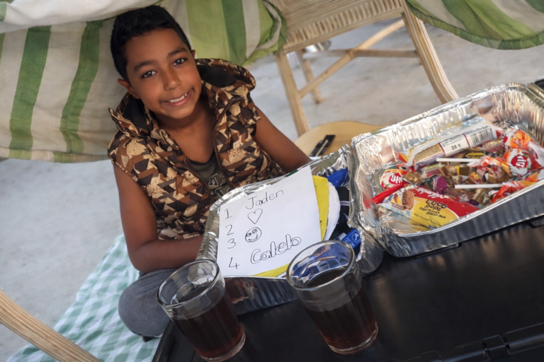 My son Under the striped tent selling treats