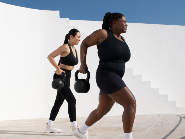 Image of two woman working our with kettle bells.