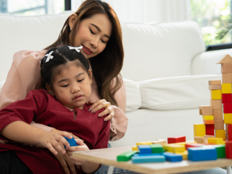 Mom helping special needs child with sensory play