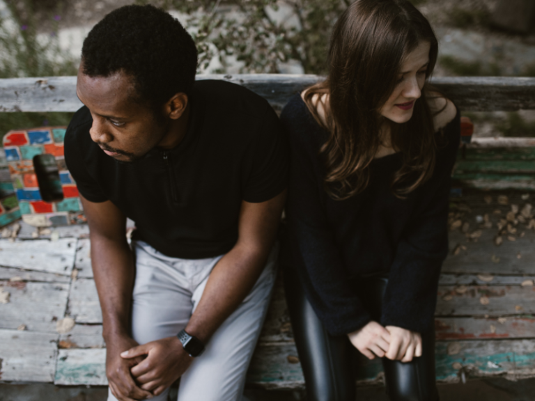 Couple sitting apart on a sofa, looking away from each other